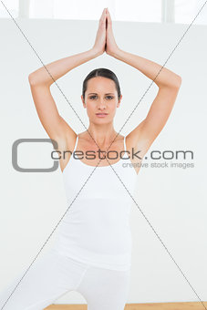 Woman with joined hands over head at a fitness studio