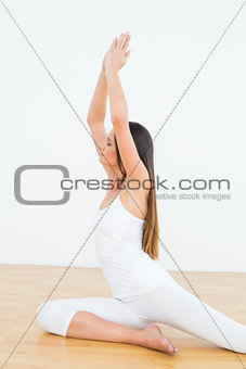 Toned woman with joined hands over head at a fitness studio