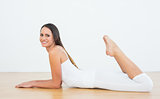 Fit woman lying on floor in fitness studio
