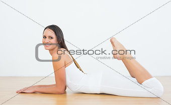 Fit woman lying on floor in fitness studio