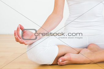 Close-up of woman in lotus pose at fitness studio