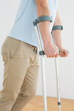 Side view mid section of a man with crutches