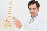 Portrait of a smiling male doctor with skeleton model