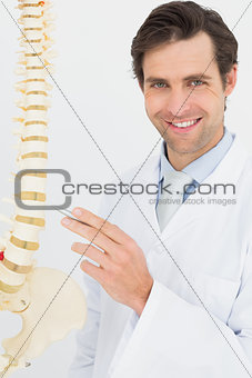 Portrait of a smiling doctor with skeleton model