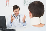 Doctor in conversation with patient at desk in office