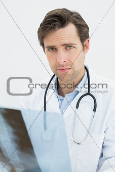 Portrait of a male doctor examining spine x-ray