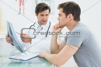 Male doctor explaining spine x-ray to patient