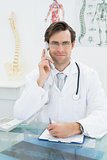 Smiling young male doctor using telephone
