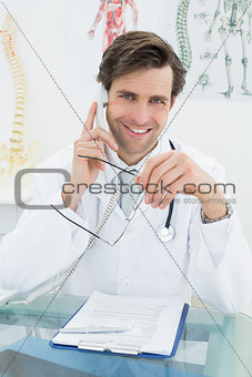 Smiling male doctor using telephone at office