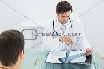 Doctor examining x-ray with patient at office