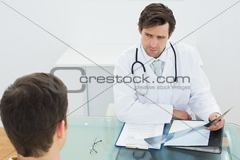 Doctor explaining x-ray reports to patient in office