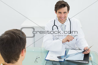 Smiling doctor explaining x-ray reports to patient