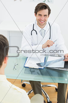 Smiling doctor explaining x-ray reports to patient