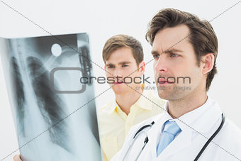 Concentrated doctor and patient examining lungs x-ray
