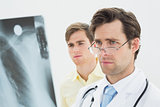 Concentrated male doctor and patient examining lungs x-ray
