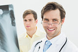 Smiling male doctor and patient examining lungs x-ray