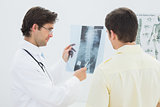 Male doctor explaining spine x-ray to patient