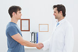 Doctor and patient shaking hands in office