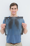 Portrait of a smiling young man holding lung x-ray