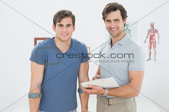 Smiling male therapist and disabled patient with reports