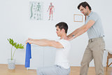 Male therapist assisting young man with exercises