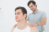 Male physiotherapist massaging a mans shoulder