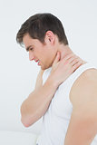 Side view of a young man suffering from neck pain