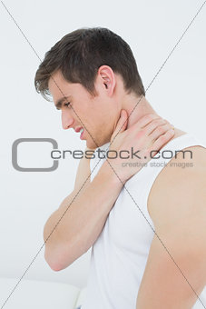 Side view of a young man suffering from neck pain