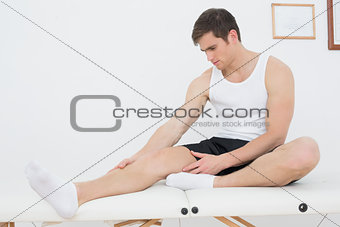 Young man sitting on examination table in medical office