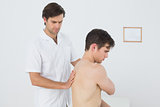 Shirtless man being massaged by a physiotherapist