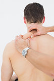Rear view of a man being massaged by a physiotherapist
