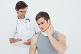 Male doctor examining a patients neck