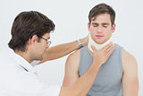 Male doctor examining a patients neck