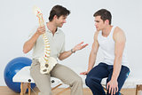 Friendly physiotherapist explaining the spine to a patient
