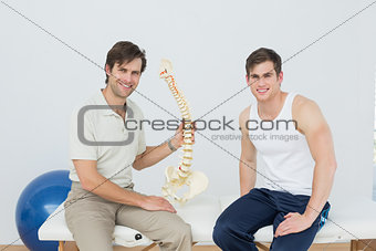 Male physiotherapist explaining the spine to patient