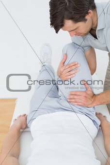 Male physiotherapist examining a mans leg