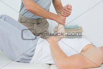 Male physiotherapist examining a young mans wrist