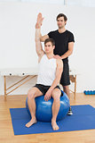 Man on yoga ball while working with physical therapist