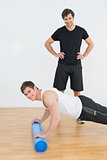 Portrait of physical therapist with young man doing push ups