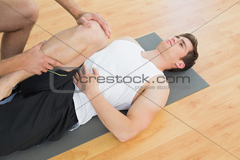 Physical therapist examining young mans leg