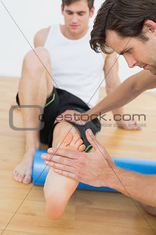 Physical therapist examining a young mans leg