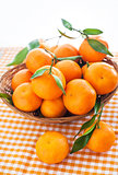Fresh tangerines with leaves in a  basket 