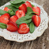 Fresh spinach salad with strawberries on a wooden background