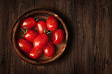 Tomatoes on the grunge wooden background
