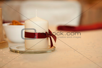 White candle on a white table