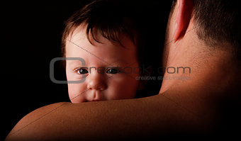 father with a young child on a black background