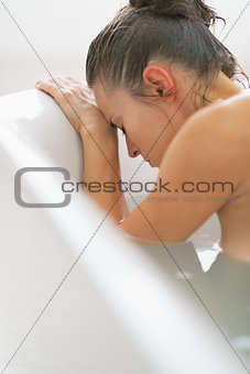 Stressed young woman in bathtub