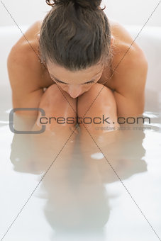 Stressed young woman sitting in bathtub