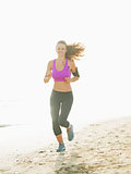 Healthy young woman running on beach