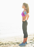 Fitness young woman standing on beach